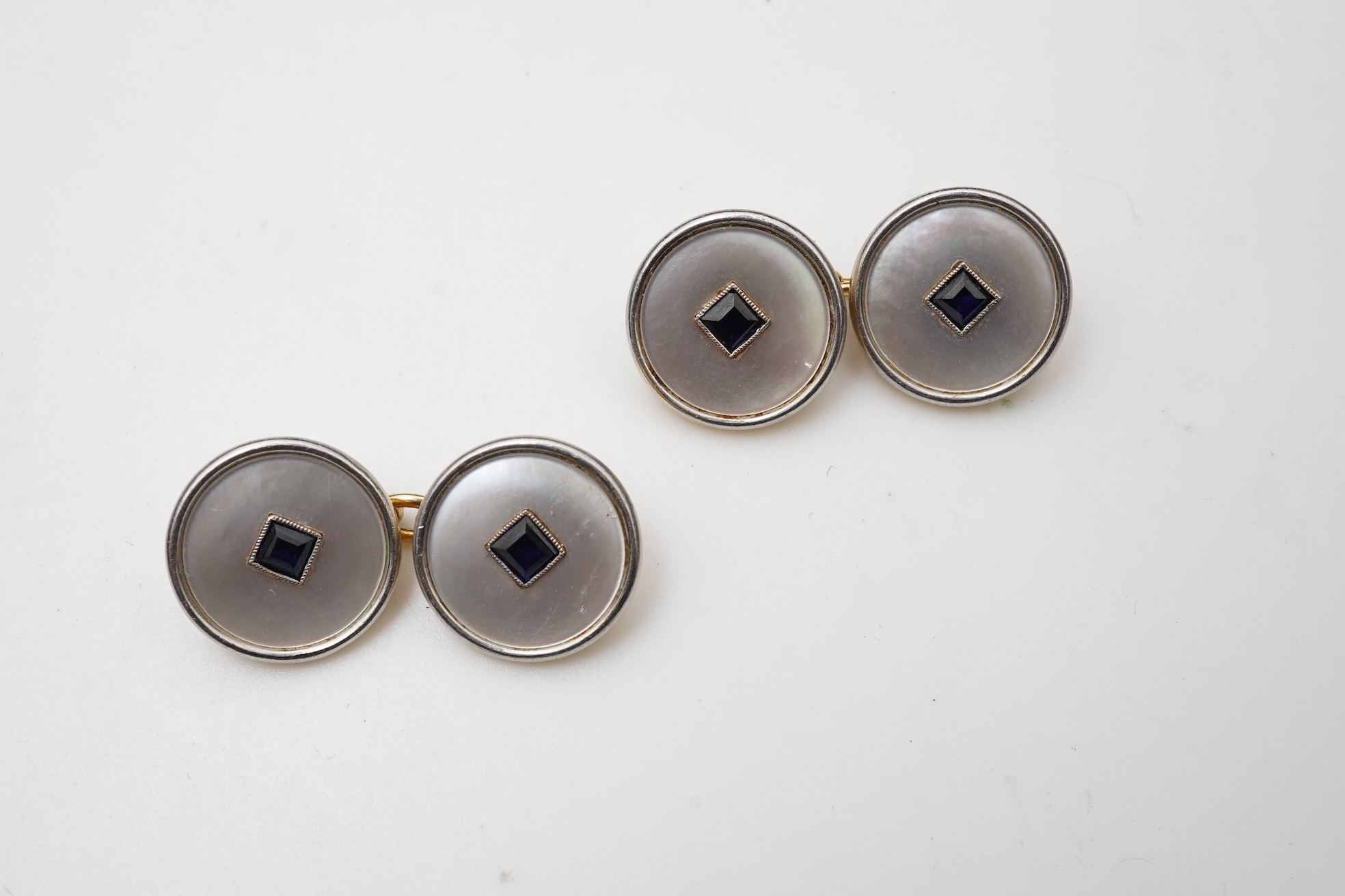 A pair of mother of pearl and sapphire cufflinks, early 20th century